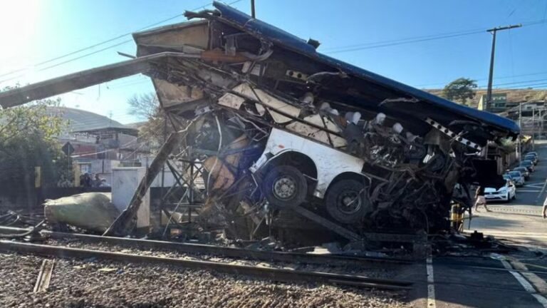 Ônibus fica completamente destruído após choque com trem